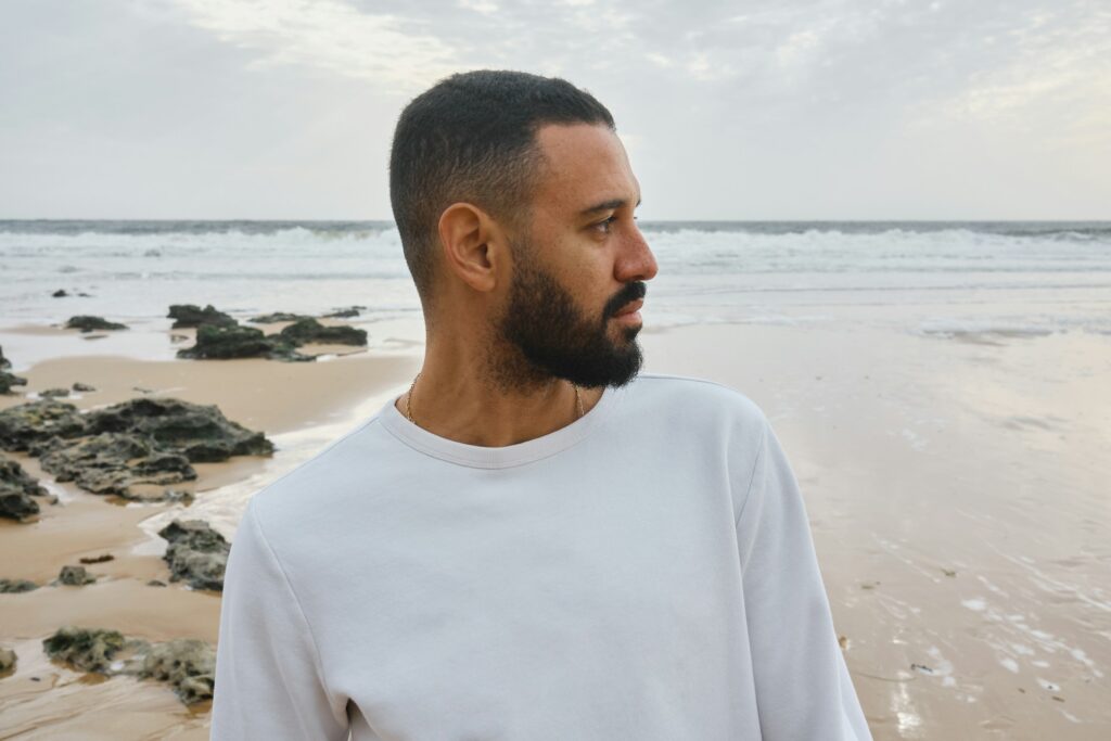 serious man on beach looking to side